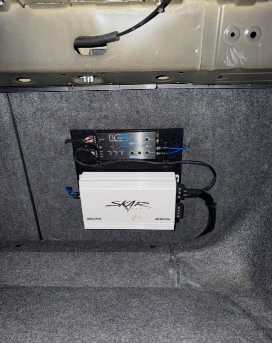 Skar amplifier and AudioControl line-output converter mounted in a trunk