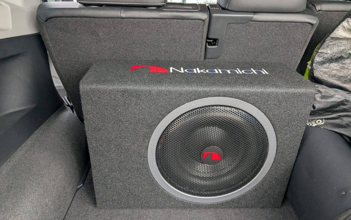 Nakamichi subwoofer in a custom-built carpeted enclosure behind the rear seats